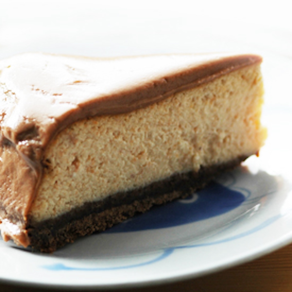 A slice of chocolate and nut cheesecake on a white plate. 