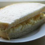egg mayonnaise sandwich, cut in half, on a white plate