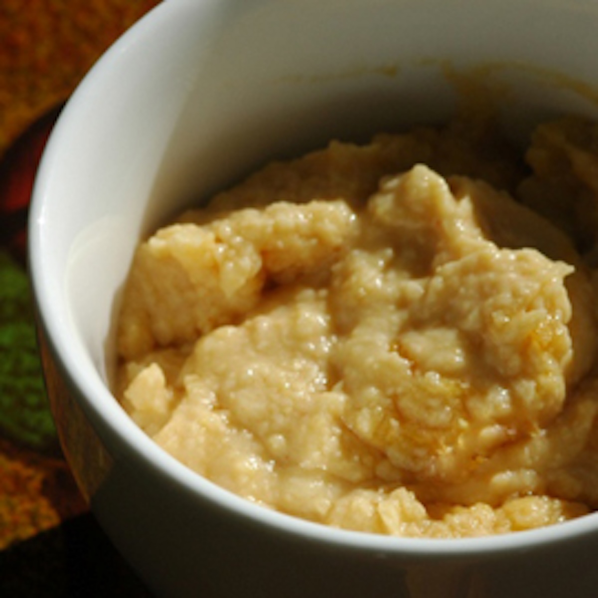 A dish of hummus in a white bowl.