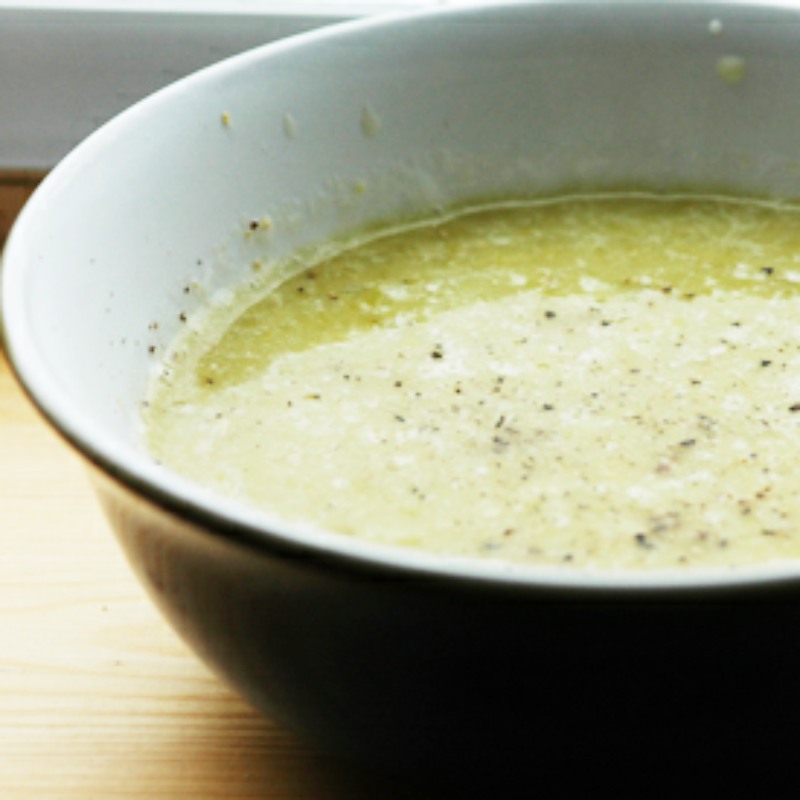 spicy pea soup in a bowl with a white inner and an olive green outer