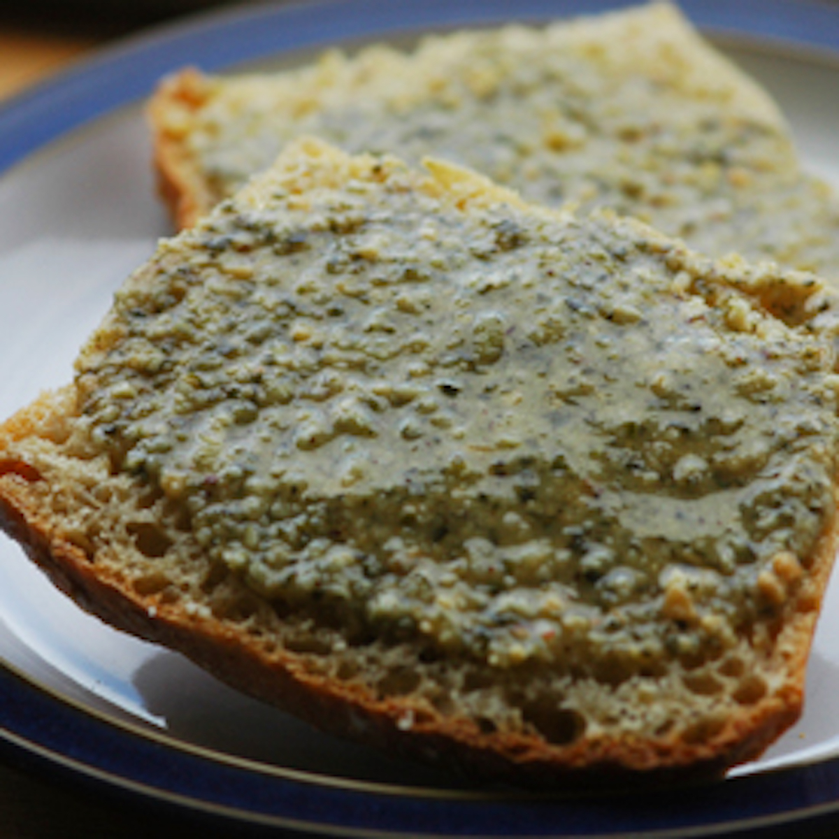 Brazil nut butter on a slice of toast, on a white plate.