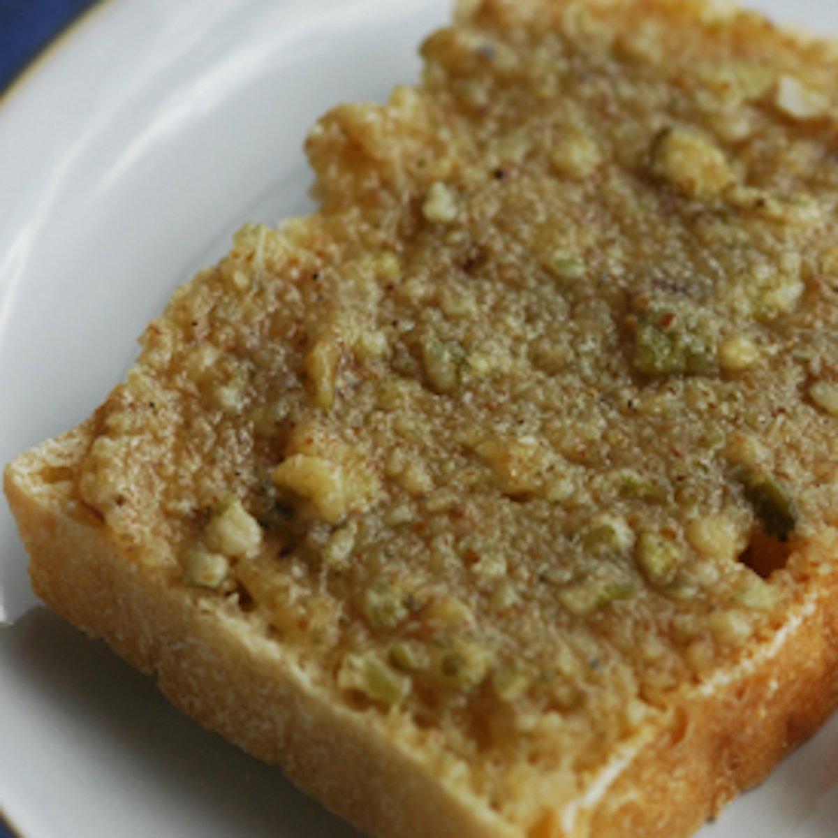 walnut butter on a slice of toast, on a white plate.