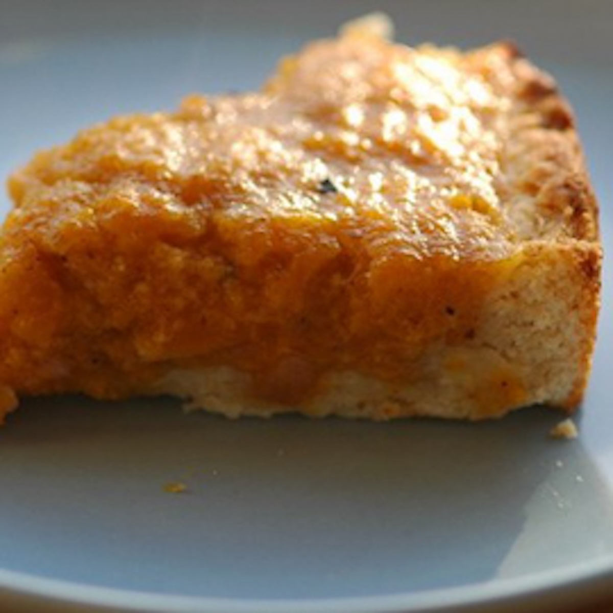 a slice of butternut squash tart on a white plate.