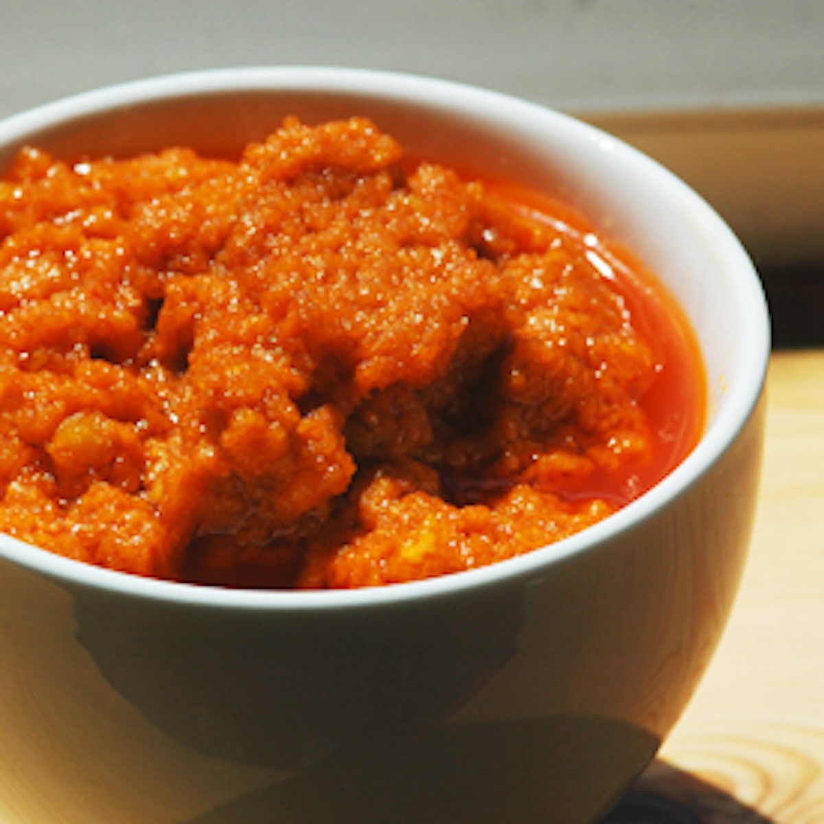 Tomato hummus in a small white dish.