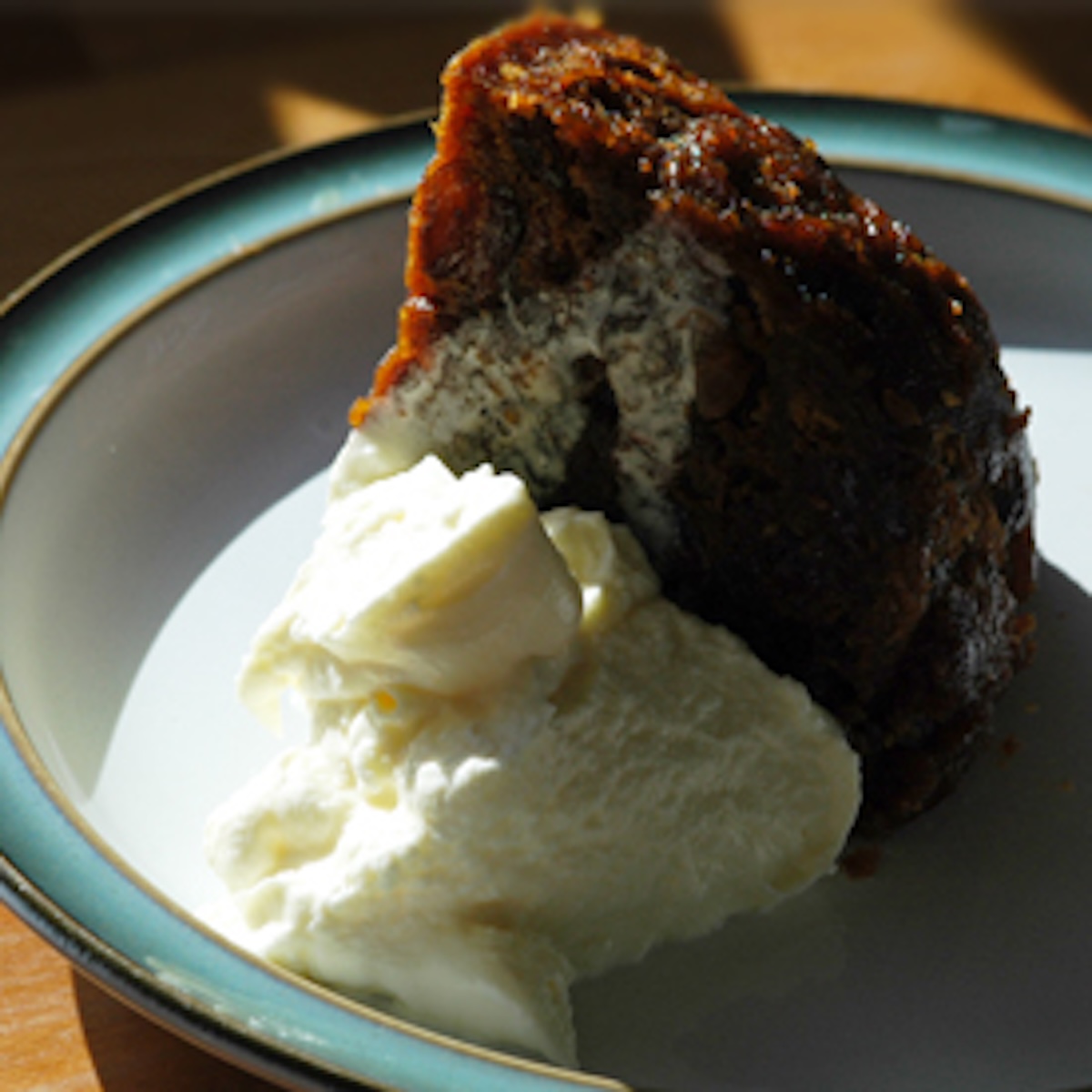 a portion of Christmas pudding, with cream, in a bowl.